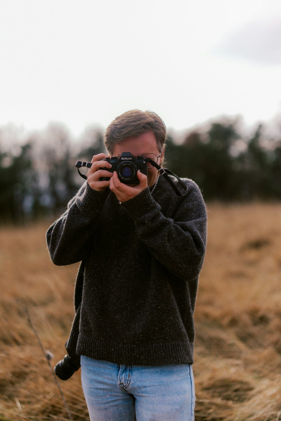 Young woman looking through a camera outdoors